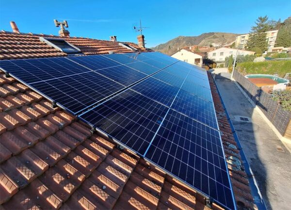 vue de près sur des panneaux solaires d'une toiture, montagne au fond, une réalisation Alpha Solaire, entreprise installation panneau solaire ardèche.